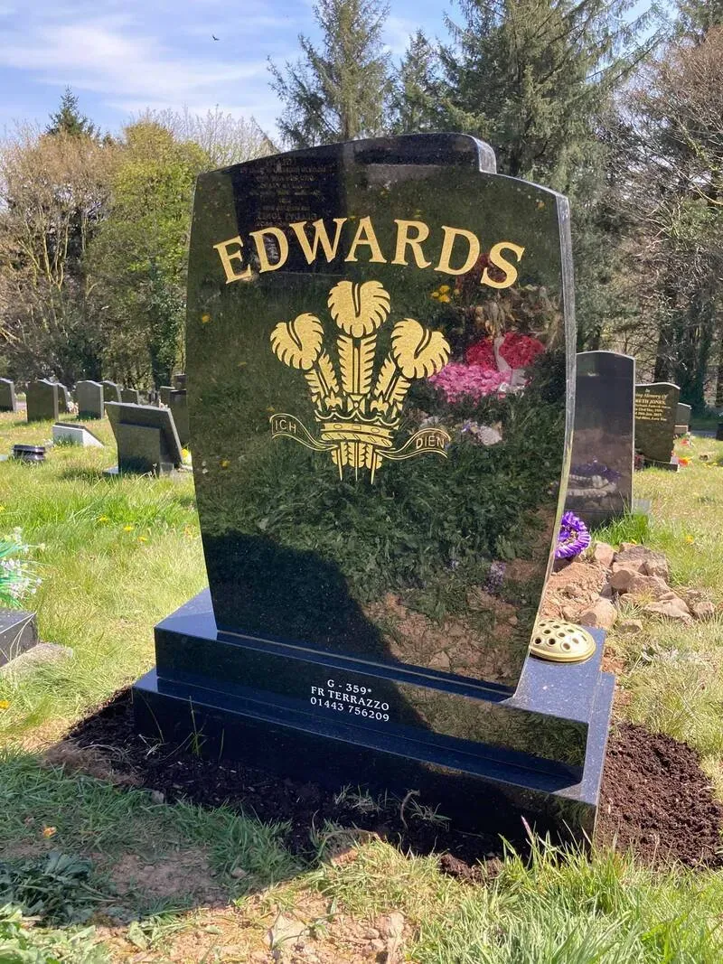 Contemporary sweeping black granite memorial with hand-gilded Prince of Wales feathers and a raised surname by FR Terrazzo, Rhondda Cynon Taff